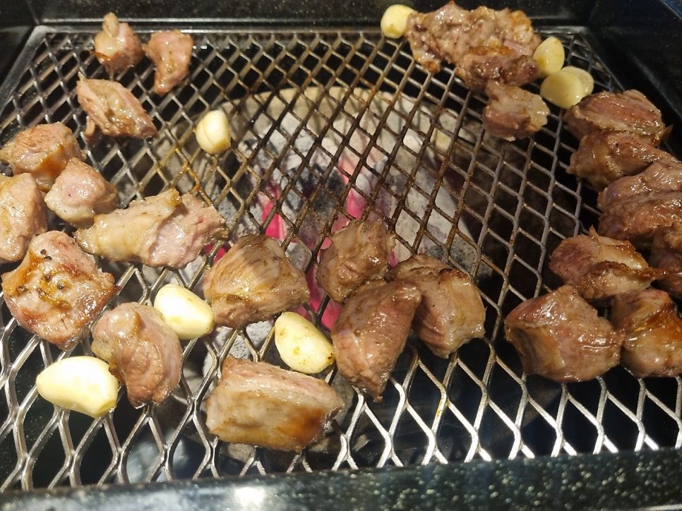 화로 위에서 마늘과 함께 익어 가는 한입 크기 통갈매기살
