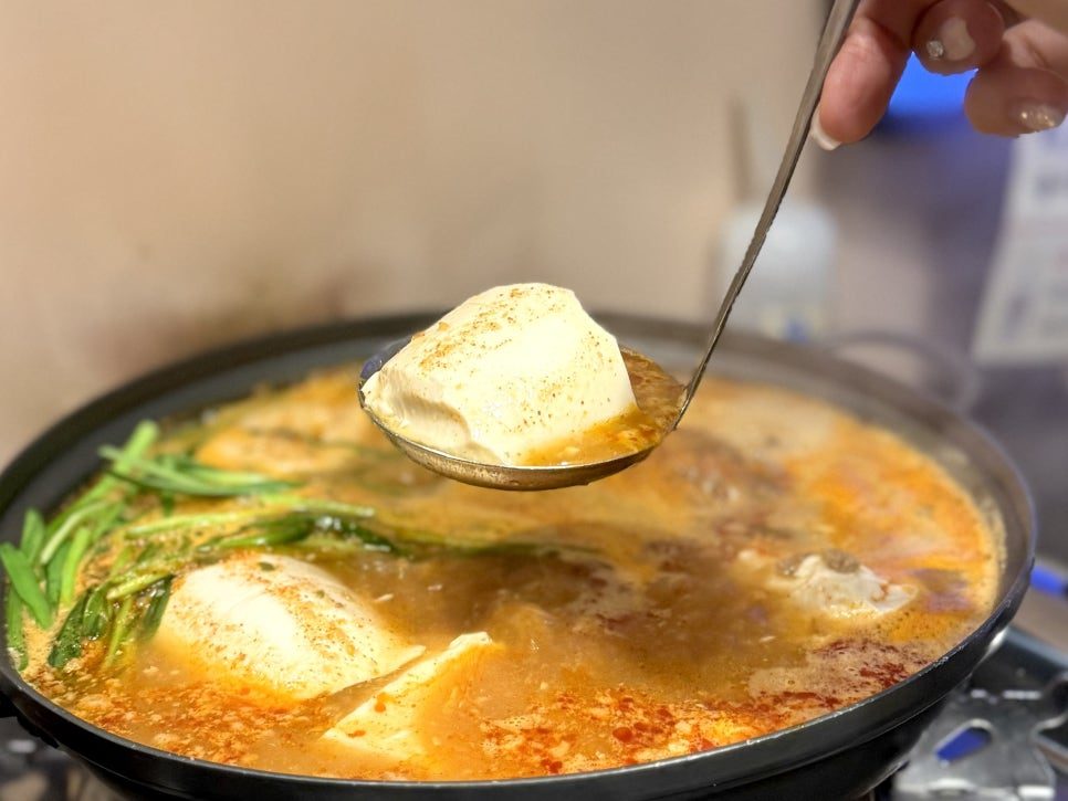 얼큰 꽃게 순두부전골에서 국자로 순두부를 떠 올린 모습