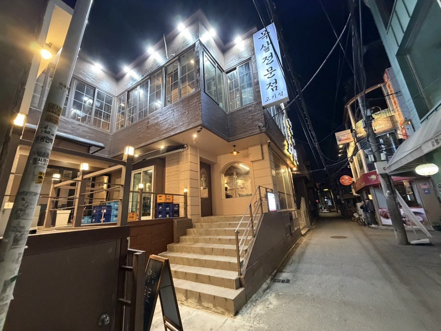 저녁 조명이 켜진 고기석 건대본점 외관