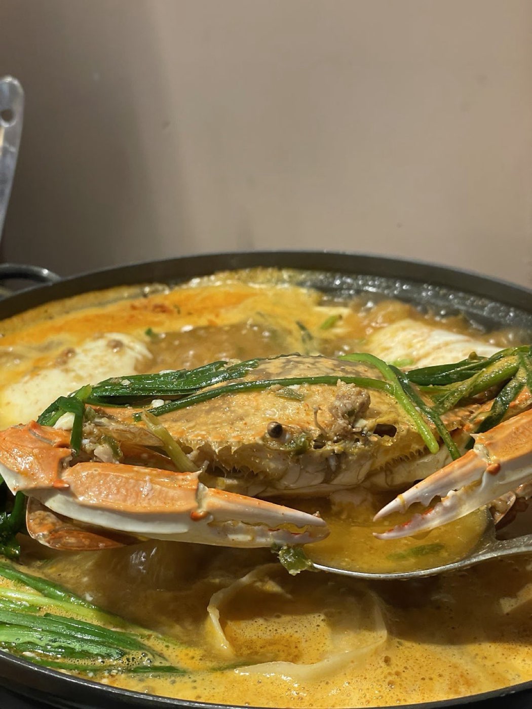 얼큰 꽃게 순두부전골에서 꽃게를 들어 올리는 모습